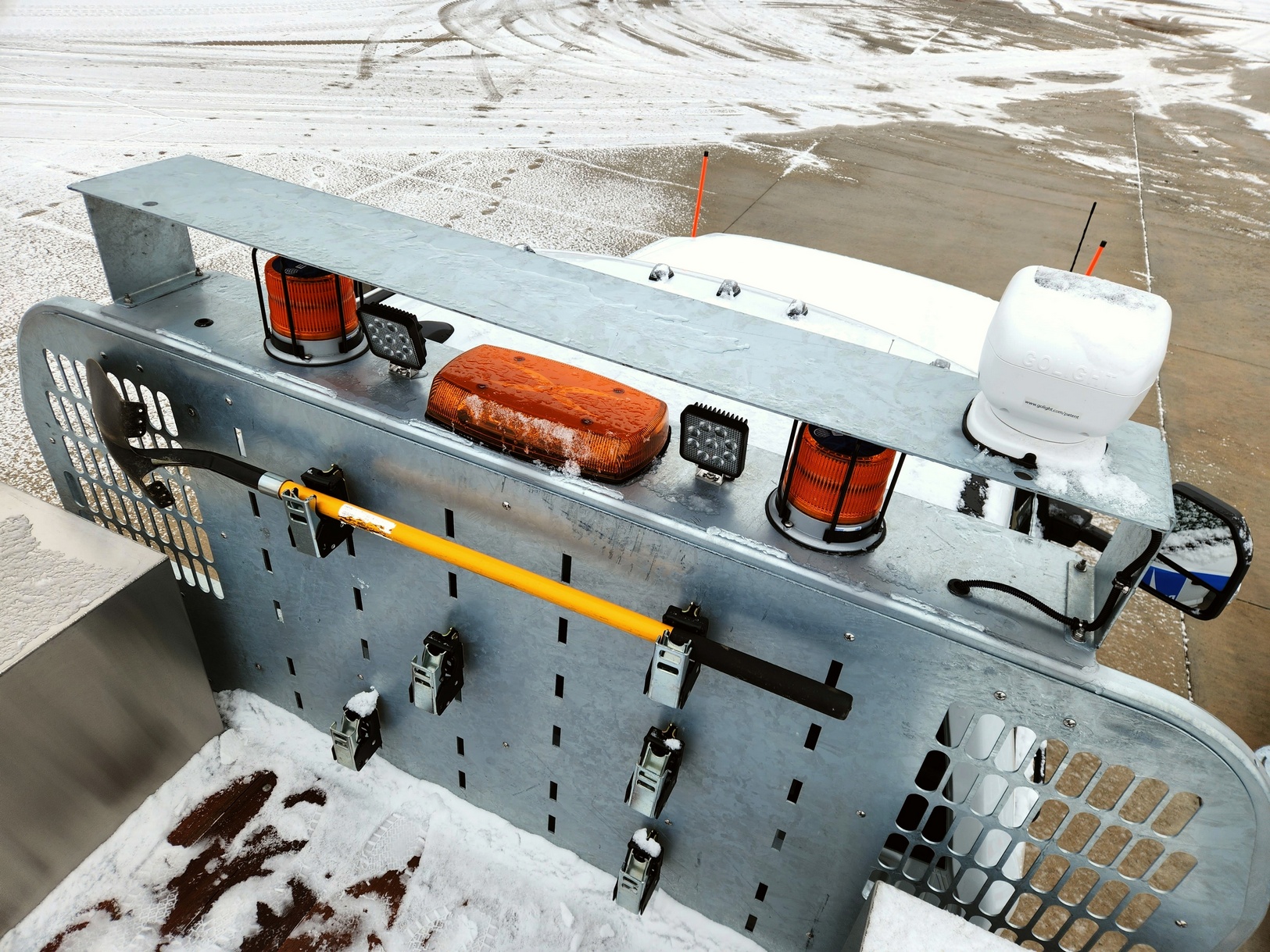Daytime view from rear and above of a Sauber Mfg. Co. LogiPerf Hot Dipped Galvanized Platform Bulkhead with several 22634 Warrior QuickLatch Tool Holder Sets installed. The truck is shown on snow covered concrete.