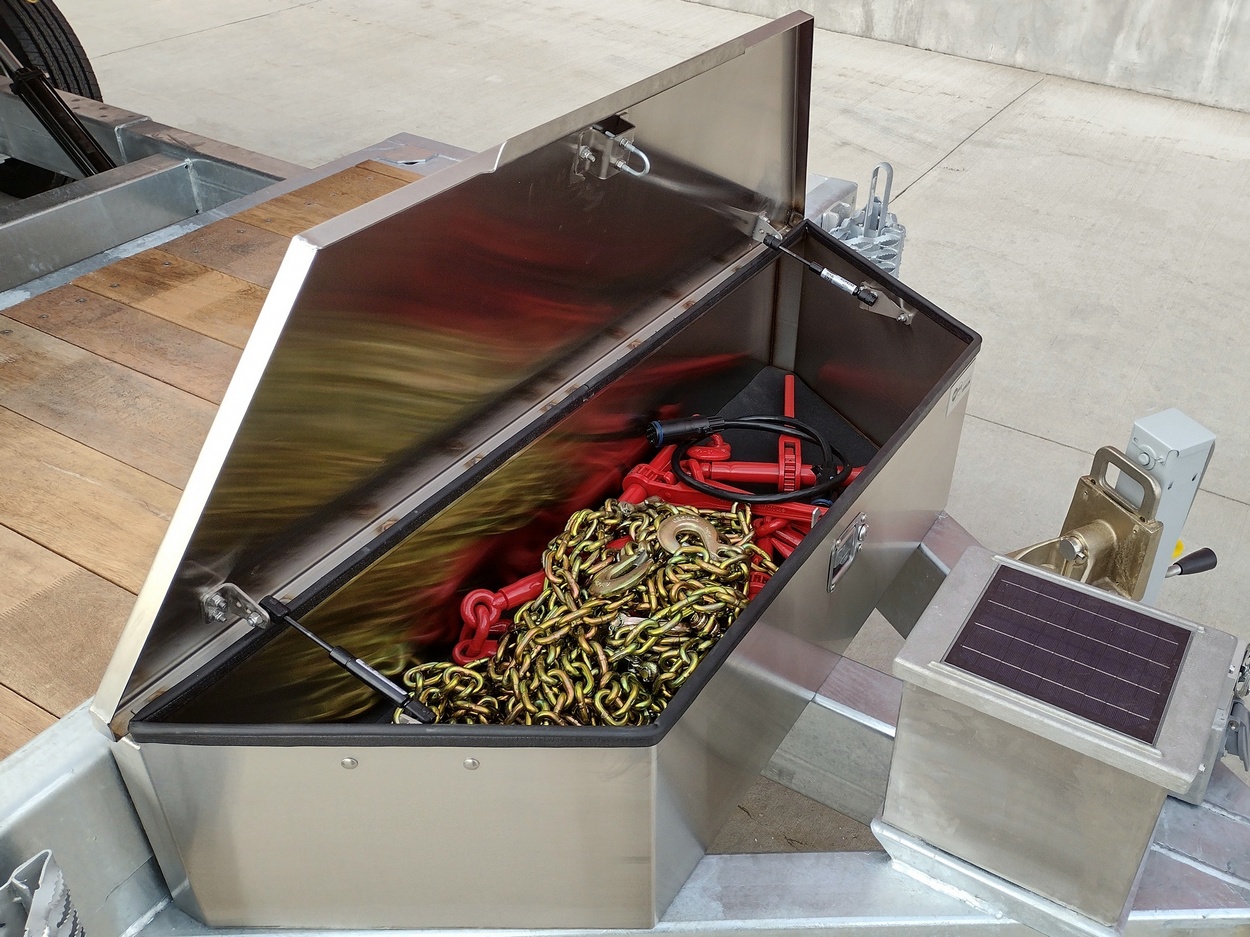 Right side view of a Sauber Mfg. Co. Stainless-Steel Toolboxes with 14-gauge material, automotive weather seal and stainless-steel latch and hinge. The trailer is shown on a concrete pad.